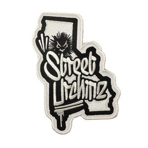 May include: A black and white embroidered patch shaped like the state of California. The patch features the text Street Urchinz in a stylized font, with a small spiky character graphic above the text and a dripping paint effect at the bottom.