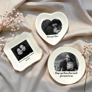 May include: Three white ceramic trinket dishes with gold trim, each featuring a black and white photo. One is heart-shaped with "I love you Mom." Another is square with "No one can take your place in my heart" and "Joan Sophia." The third is round with "I hope you know how much you mean to me."