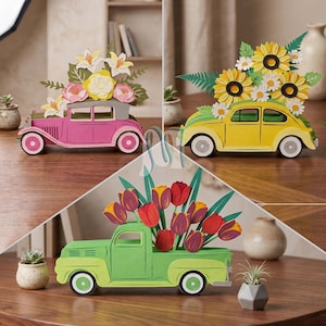 May include: Three decorative wooden vehicle cutouts featuring floral arrangements. A pink vintage car with lilies and roses, a yellow compact car with sunflowers and daisies, and a green pickup truck carrying a bouquet of red and purple tulips.