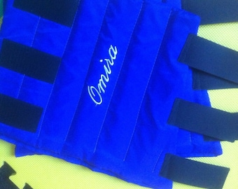 May include: Blue horse leg wraps with black straps and the name "Omnia" embroidered in white.