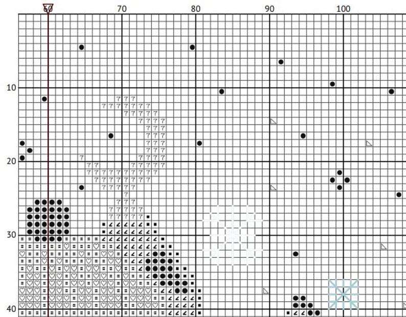 May include: A cross-stitch pattern grid with various symbols and numbers. The design includes black circles, triangles, and heart shapes, along with the number 7 and the question mark symbol. The grid is divided into squares, creating a detailed pattern.