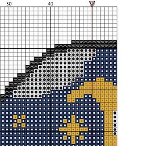 May include: A cross-stitch pattern chart with a grid of squares. The design features a crescent moon and stars in gold against a dark blue background, with a black and white section at the top. The chart is marked with numbers.