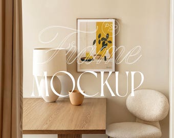 May include: A room interior with a wooden table, a white lamp, and a framed art print. The art print features a yellow background with a plant illustration. The text "Frame Mockup" is overlaid on the image. A beige chair is on the right.