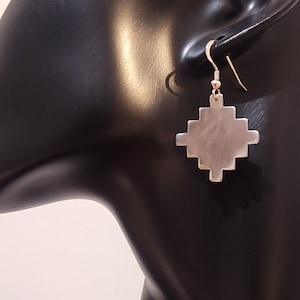 Puede incluir: Pendientes de plata con diseño de cruz geométrica.