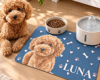 May include: A rectangular blue pet feeding mat featuring a watercolour-style illustration of a brown curly-haired dog, white bone and heart icons, paw prints, and the name LUNA in white capital letters, positioned under a food bowl and water fountain.