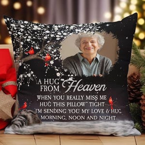Peut inclure: Coussin d&eacute;coratif noir avec une photo de femme, un arbre et des cardinaux rouges. Le texte sur le coussin dit "A HUG FROM Heaven" et un message sur l'amour et les c&acirc;lins.