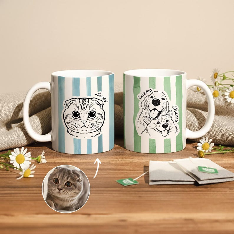 May include: Two white ceramic mugs with pet portraits. One mug has a blue and white striped pattern with a cat illustration and the name "Luccy". The other mug has a green and white striped pattern with dog illustrations and the names "Gizmo" and "Churro".