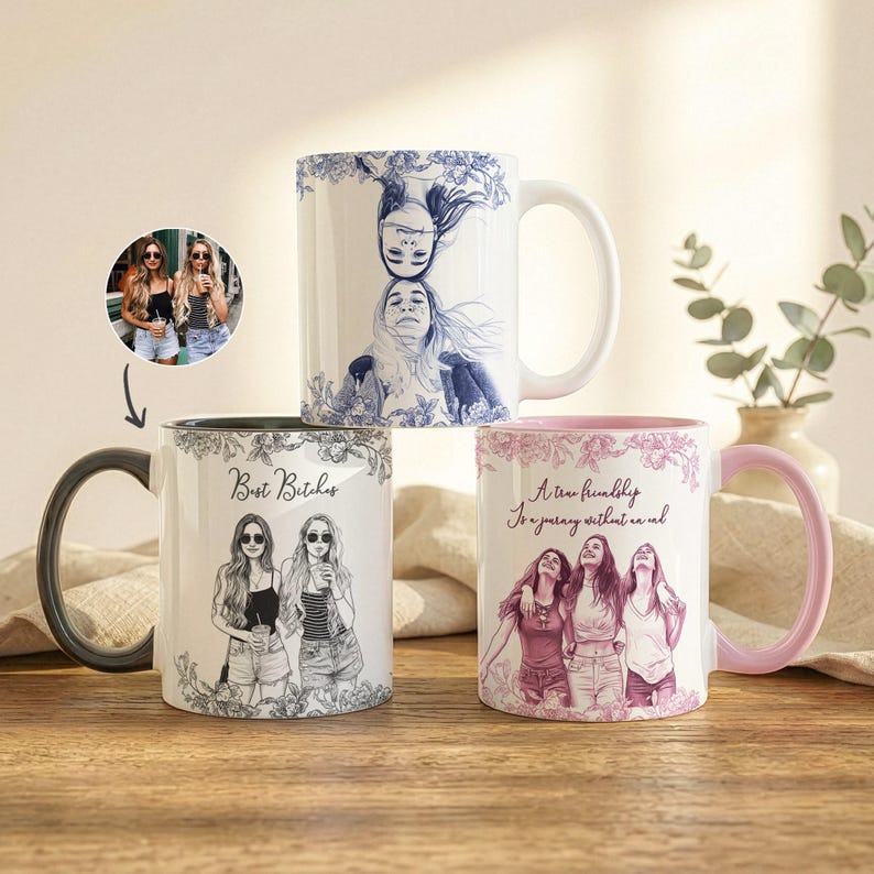 May include: Three white ceramic mugs with custom illustrations and text. One mug features a black and white illustration of two women with the text "Best Bitches". Another mug has a blue and white illustration of two women. The third mug has a pink illustration of three women with the text "A true friendship is a journey without an end".