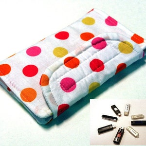 May include: A white fabric USB drive case with a colorful polka dot pattern in orange, pink, and yellow. The case is quilted and folded over. Several USB drives are arranged in a circle in the lower right corner.
