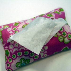 May include: A rectangular tissue holder with a floral pattern in pink, green, and white. White tissues are partially pulled from the opening. The holder is made of fabric and appears to be handmade.