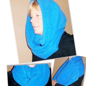 Könnte beinhalten: Ein leuchtend blauer Rundschal und Kapuze. Die Kapuze wird über dem Kopf getragen, und der Schal umschließt den Hals. Der Stoff wirkt weich und bequem, ideal für kühleres Wetter. Der Schal hat einen auffälligen Blauton.