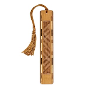 May include: A rectangular wooden bookmark featuring a central panel with laser-etched geometric lines, circles, and small triangles. The bookmark is constructed from alternating light and dark wood strips and includes a gold-colored cord tassel.