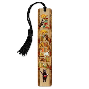 May include: Wooden bookmark featuring a whimsical illustration of cats reading books on shelves. The bookmark has a black tassel attached. The cats are depicted in various colors, including orange, black, and white.