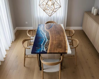 Könnte beinhalten: Ein rechteckiger Esstisch mit einzigartigem Design. Eine Seite zeigt eine natürliche Holzmaserung, während die andere Seite ein blau-weißes Harzdesign mit Meereswellen aufweist. Der Tisch wird von einem schwarzen Metallrahmen getragen.