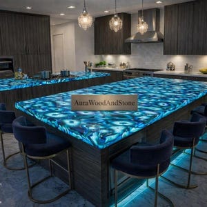 May include: A modern kitchen with dark wood cabinetry and a large island featuring a blue, patterned countertop. The island has seating with dark blue chairs. Overhead, there are decorative light fixtures.
