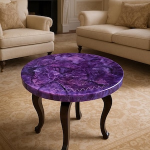 May include: A circular coffee table featuring a striking purple top and dark brown, curved legs. The tabletop has a textured, marbled effect. The table is a decorative piece of furniture, suitable for a living room.
