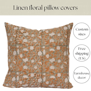 May include: Linen floral pillow covers with a floral pattern in orange and white on a gray background. The pillow has a quilted design. Text on the image says "Custom sizes" and "Farmhouse decor."