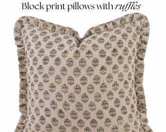 Könnte beinhalten: Ein quadratisches Kissen mit einem floralen Blockdruck-Design in Blau und Beige. Das Kissen hat einen gerüschten Rand und der Text "Block print pillows with ruffles" wird oben angezeigt.