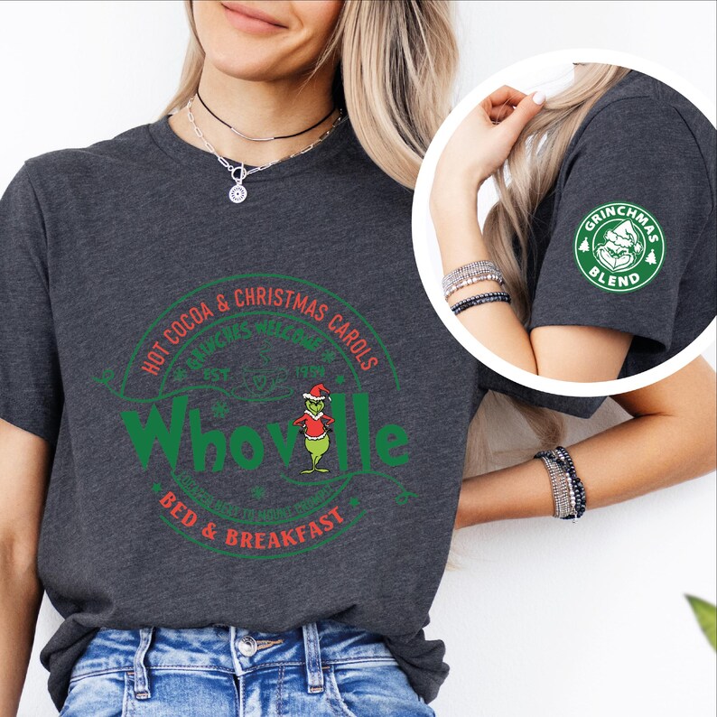 Peut inclure: Un t-shirt gris fonc&eacute; avec un motif circulaire vert et rouge qui dit "Whoville Bed & Breakfast" avec un personnage de dessin anim&eacute; du Grinch. Le motif dit &eacute;galement "Hot Cocoa & Christmas Carols" et "Grinchmas Welcome 1958".