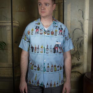 Vintage 1960s Novelty Print Cotton Blend Loop Collar Shirt with Liquor Bottle Theme from Virgin Islands in Rare Blue Colorway