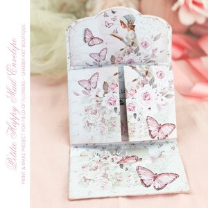 May include: A printable paper craft project for a happy mail envelope. The envelope features a floral design with butterflies and a girl reading a book. The text "Petitie Happy Mail Envelope" and "PRINT & MAKE PROJECT FOR FIELD OF FLOWERS - SHABBY ART BOUTIQUE" is printed on the envelope.