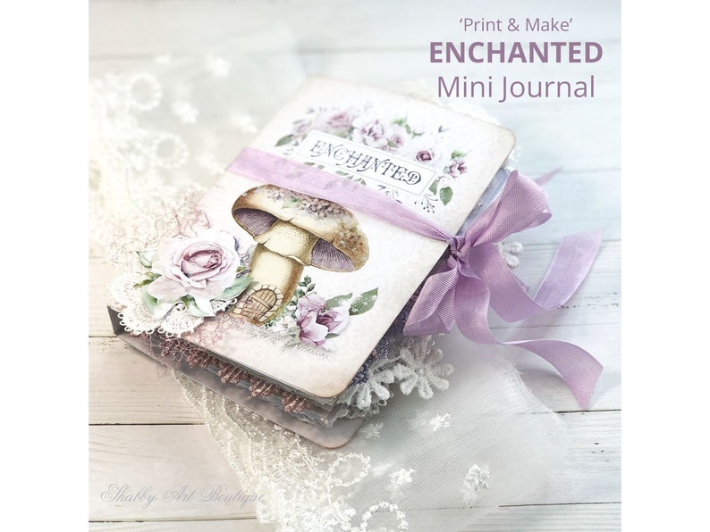 May include: A small, purple and white journal with a mushroom and floral design. The journal is tied with a purple ribbon and has the text "'Print & Make' ENCHANTED Mini Journal" on the cover.