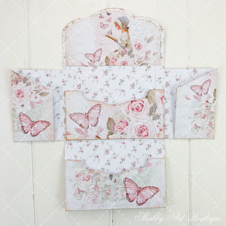 May include: A set of four decorative envelopes with a floral and butterfly design. The envelopes are made of paper and have a vintage aesthetic. The envelopes are folded and ready to be used.