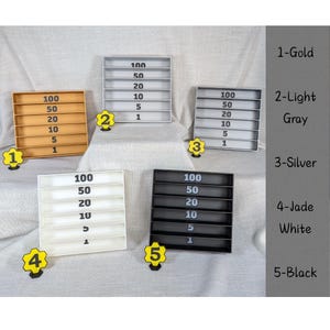 May include: Five rectangular coin organizers in gold, light gray, silver, jade white, and black. Each organizer has slots labeled with numbers 1, 5, 10, 20, 50, and 100. The colors are labeled 1-Gold, 2-Light Gray, 3-Silver, 4-Jade White, and 5-Black.