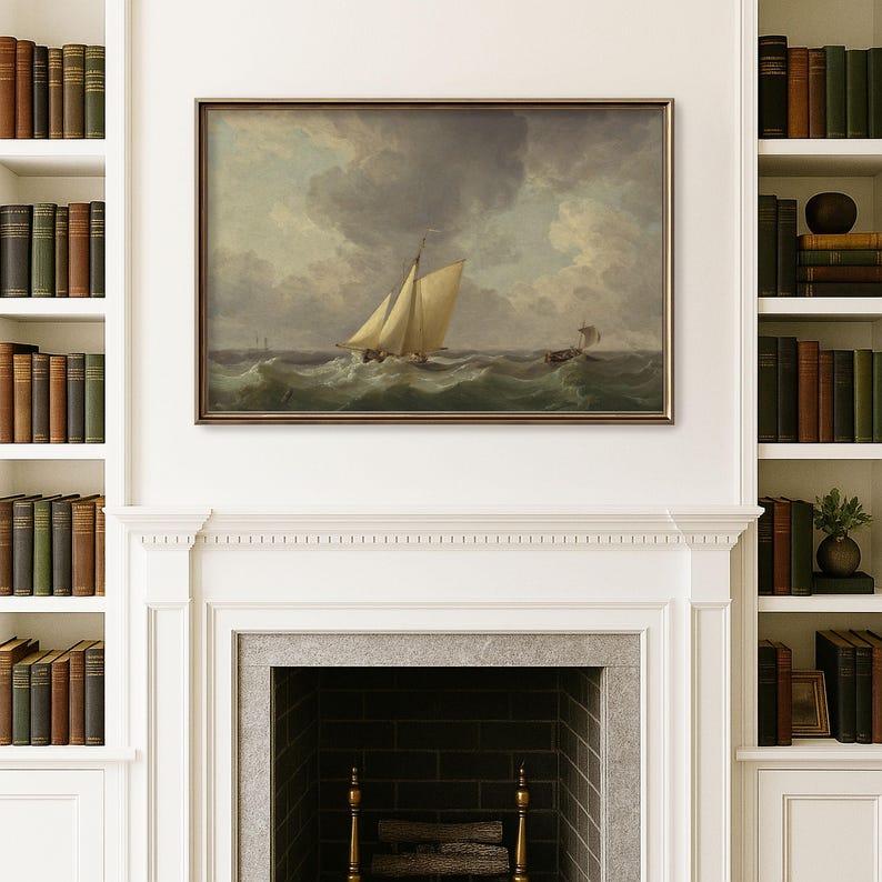 May include: A framed painting of a sailboat at sea, with a stormy sky overhead. The artwork is displayed above a fireplace, flanked by bookshelves filled with antique books. The painting's frame is a dark, warm color.