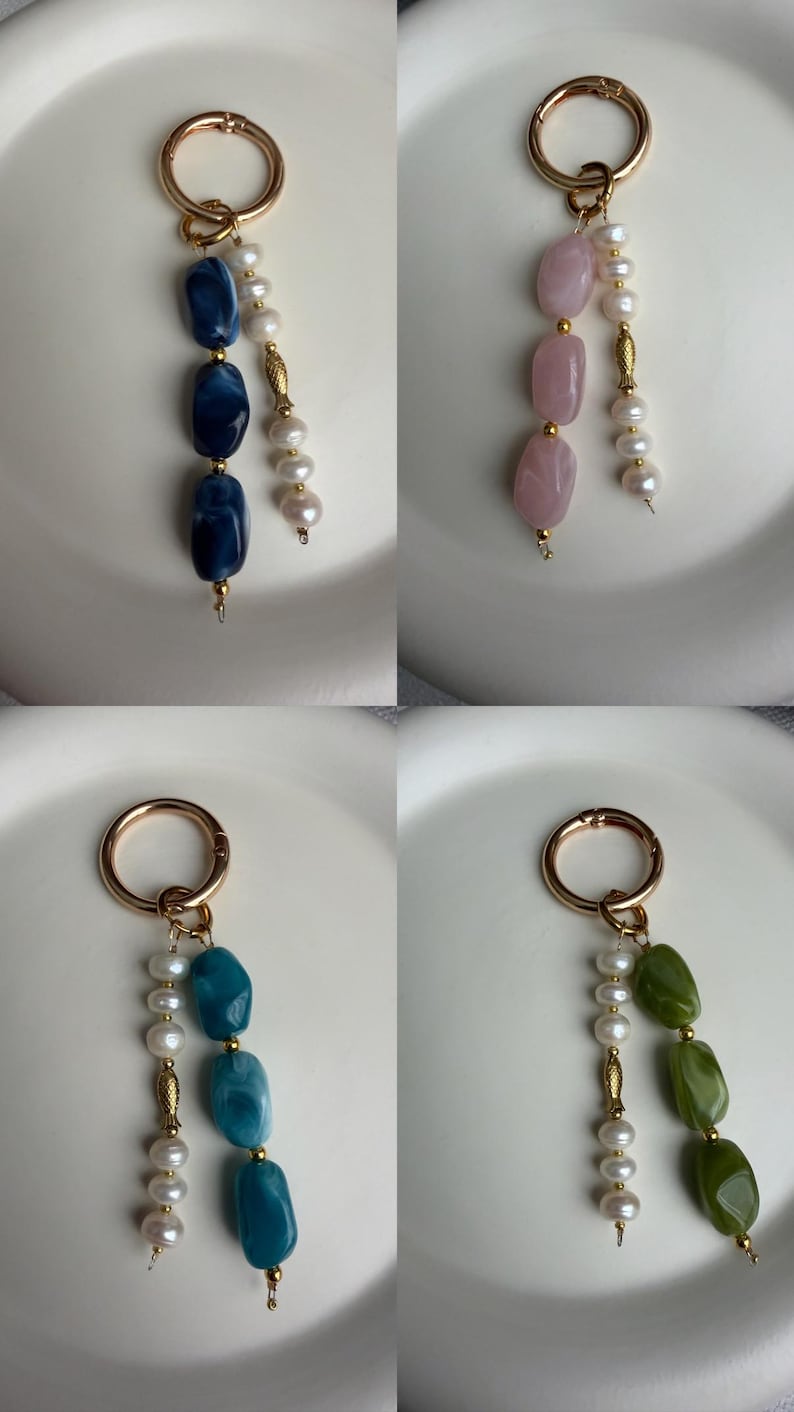 Puede incluir: Cuatro llaveros con cierres dorados. Cada llavero presenta un dise&ntilde;o diferente: cuentas de piedras preciosas azules, rosas, turquesas y verdes, combinadas con perlas blancas. Los llaveros se muestran sobre una superficie blanca.