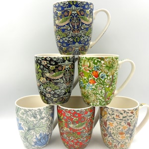 May include: Six ceramic mugs with different floral and bird patterns. The mugs are stacked in a pyramid shape. The mugs are all white with a variety of colours and designs.
