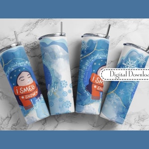 May include: Four blue and white winter-themed tumblers with gold accents. One tumbler features a cartoon person wearing a red scarf and the text "I smell snow".