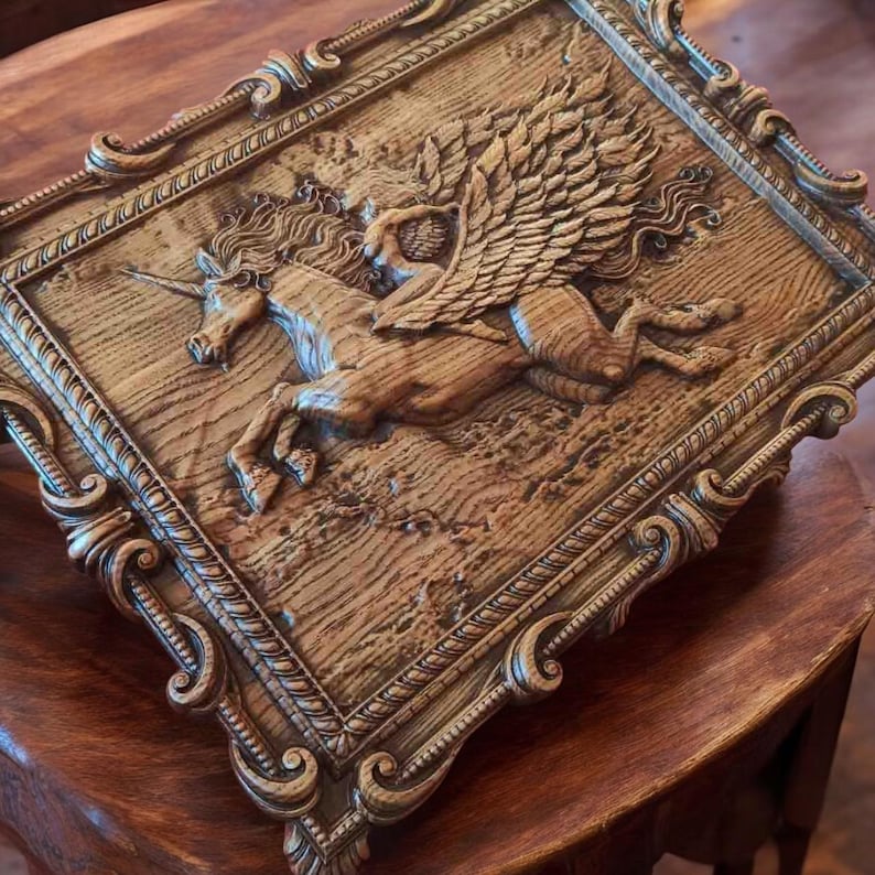 May include: A wooden wall art piece with a detailed carving of a winged unicorn. The unicorn is depicted in a running pose with a figure riding on its back. The piece is framed in a decorative, ornate frame.