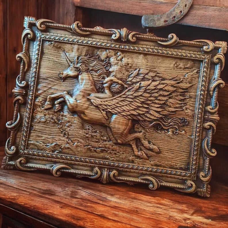 May include: A wooden carving of a winged unicorn in a decorative frame. The unicorn is depicted in a running pose with its wings spread out. The carving is detailed and realistic, with visible wood grain.