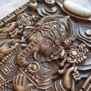 May include: A detailed wooden carving of the Hindu deity Ganesha, with intricate details and a rich brown color.