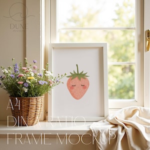 May include: A white framed print featuring a cartoon strawberry with closed eyes. The print is displayed on a windowsill next to a woven basket of flowers. The text "A4 DIN RATIO FRAME MOCKUP" is at the bottom.