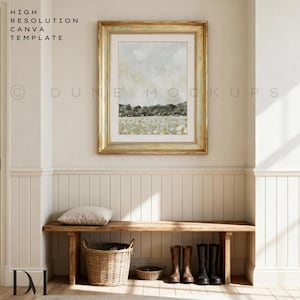 May include: A framed landscape print with a gold frame hangs above a wooden bench. The artwork features a muted colour palette with a field of flowers and a forest line. A woven basket and boots are below.