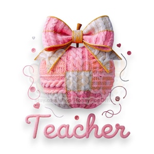 Könnte beinhalten: Ein gestrickter Apfel in Rosa und Weiß mit einer Schleife und goldenem Besatz, mit dem Wort "Teacher" in rosa Schrift. Der Apfel besteht aus verschiedenen Strickmustern mit dekorativen Knöpfen und Fadenakzenten.