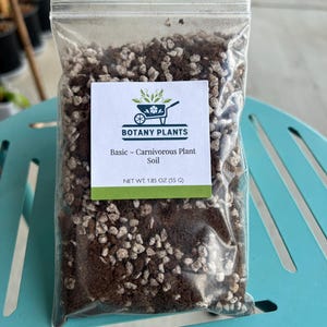 May include: A clear plastic bag filled with soil for carnivorous plants. The bag has a white label with the text "BOTANY PLANTS" and "Basic - Carnivorous Plant Soil". The net weight is 1.85 oz (55 G). The soil is a mix of brown and light-colored particles.