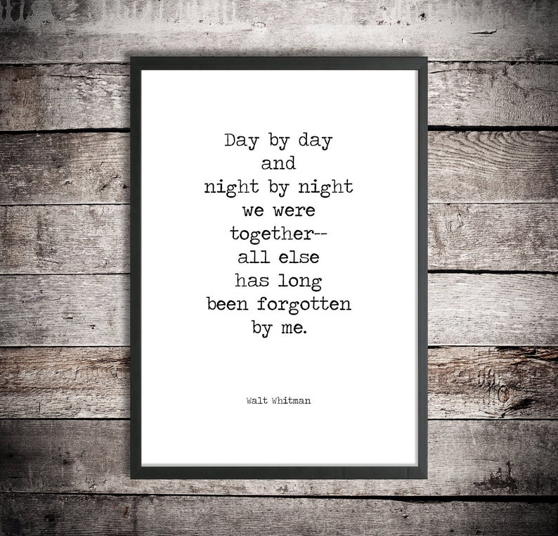 May include: Black and white typography print with a quote by Walt Whitman: "Day by day and night by night we were together-- all else has long been forgotten by me."