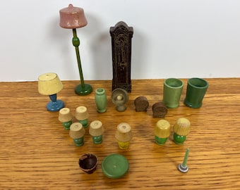 Puede incluir: Una colección de muebles de madera en miniatura para casa de muñecas que incluye una lámpara de pie con pantalla rosa, un reloj de pie marrón oscuro, una lámpara de mesa azul, varias lámparas pequeñas con pantallas amarillas, tazas verdes y accesorios.