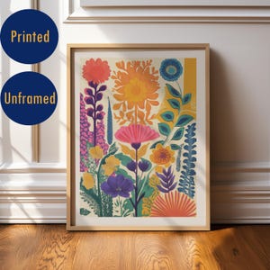 Puede incluir: Una impresión artística floral enmarcada con una vibrante variedad de flores estilizadas en tonos naranja, rosa, amarillo, morado y azul. La impresión está sobre un fondo crema y enmarcada en madera clara. El texto "Printed" y "Unframed" están en la imagen.