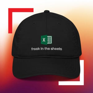May include: Black baseball cap with a green and white Excel logo and the text "freak in the sheets" embroidered on the front.