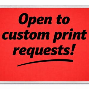 May include: A red rectangular sign with a silver frame. The sign displays the text "Open to custom print requests!" in bold black font. A black curved line underlines the word "requests".