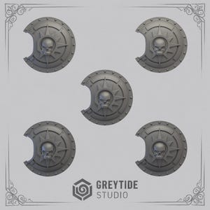 May include: Five grey, circular shields featuring a skull and sunburst design. Each shield has a cut-out section. The shields are arranged on a light grey background. The text "GREYTIDE STUDIO" is visible at the bottom.