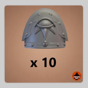May include: A set of 10 grey resin shoulder pads for miniature figures. Each pad features a raised eye emblem centred above a pointed decorative element, surrounded by small circular rivets along the curved edges. The text x 10 is visible.