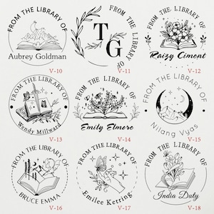 May include: Set of 10 round black and white rubber stamps with different designs. Each stamp features a book, a mountain, a flower, a butterfly, a crescent moon, a sword, and a hand. The stamps are labeled with the names Aubrey Goldman, Wendy Millward, Bruce Emma, Raizy Ciment, Nilang Vyas, India Duty, Emily Elmore, Emilee Ketring, and T.G. Each stamp also has a number from V-10 to V-18.