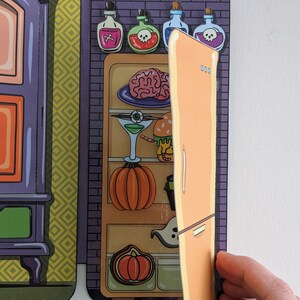 May include: A Halloween-themed refrigerator with a door that opens to reveal a variety of spooky treats, including a brain, an eyeball, a pumpkin, and a ghost. The refrigerator is decorated with a brick pattern and has a shelf with four potion bottles.