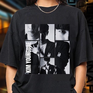 Könnte beinhalten: Schwarzes T-Shirt mit einem grafischen Druck einer Gruppe von Männern in Schwarzweiß. Der Text "KIM YOUNGDAE" ist vertikal auf der linken Seite des Grafikdrucks gedruckt.