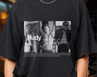 Puede incluir: Camiseta negra con un estampado blanco de tres hombres. La impresión incluye el texto "Rudy" y una firma.